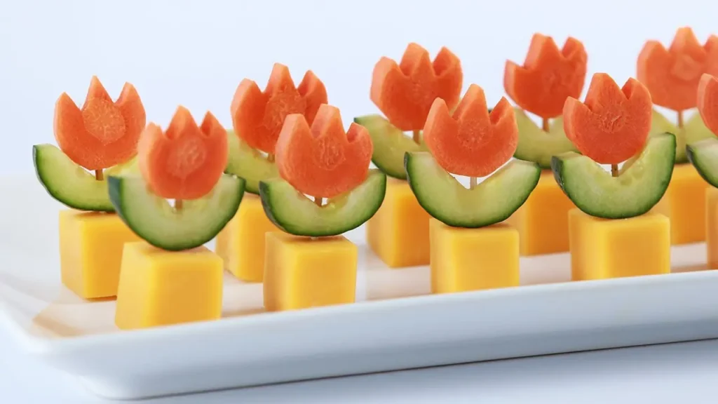 Aperitivo saudável com queijo, pepino e cenoura no formato da Fire Flower (flor de fogo) que faz Mario lançar bolas de fogo